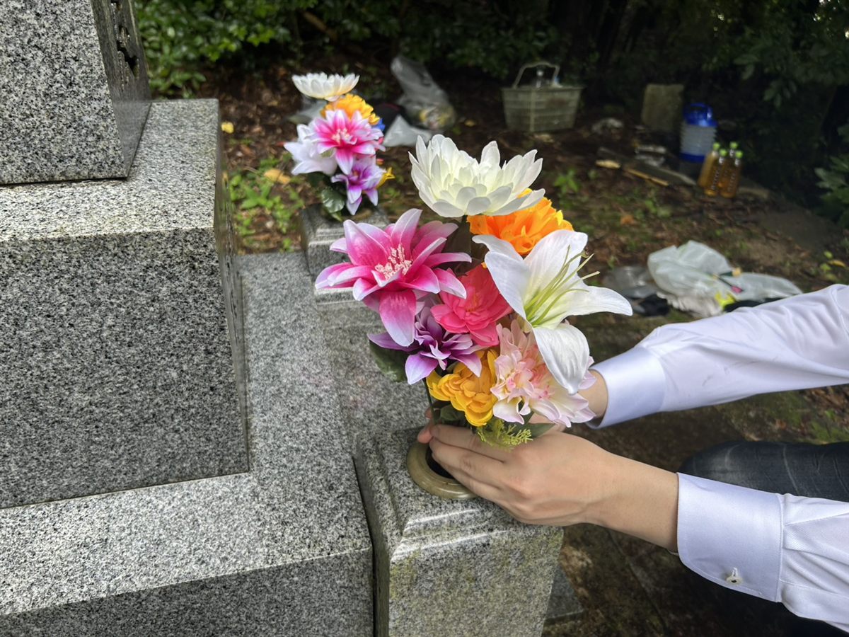 季節のお花を、両手でお供えする手元