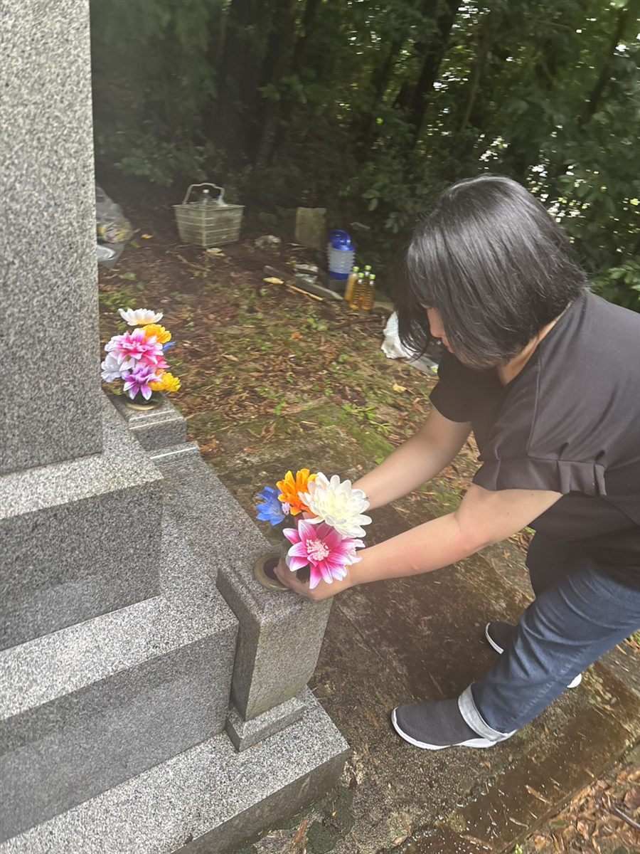お墓にお花を活けるご家族